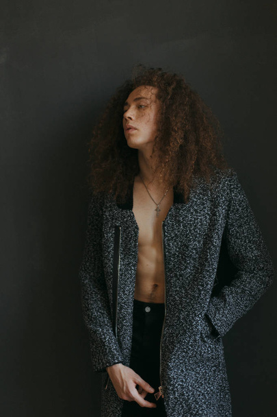 Portraits of a guy with an attractive appearance, curly hair and stylish clothes - Zdjęcie, obraz