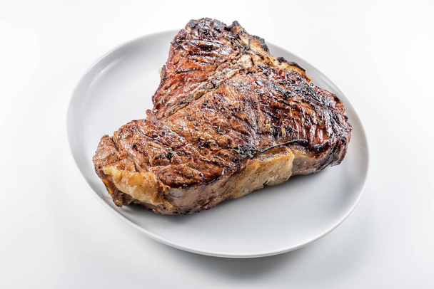 White round plate with Whole grilled T-bone steak isolated on white background - Фото, зображення