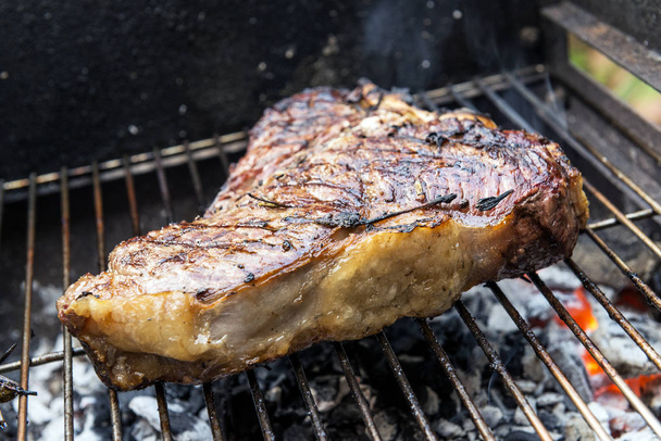 Whole T-Bone steak cooking on grill of barbecue - Photo, Image