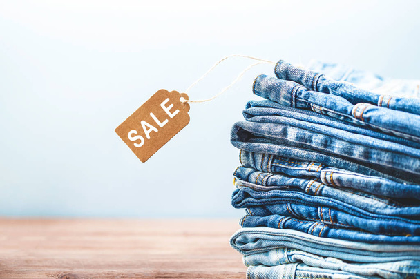 Concept sales, Black Friday discounts with tag, blue jeans on a light background Copyspace. - Zdjęcie, obraz