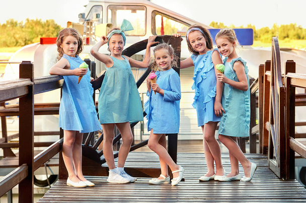 Group 5 five fashion lady kids in elegant striped dresses,marine style. Little girls in designer collection childrens clothes. Girlfriends smile,standing on bridge. Vacation,fashionable concept. - Фото, изображение