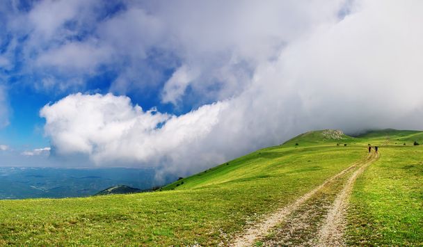 Panorama van de groene heuvel en de grote witte wolk - Foto, afbeelding