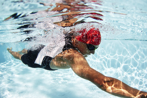 Mannelijke zwemmer atleet onderwater zwemmen in zwembad - Foto, afbeelding
