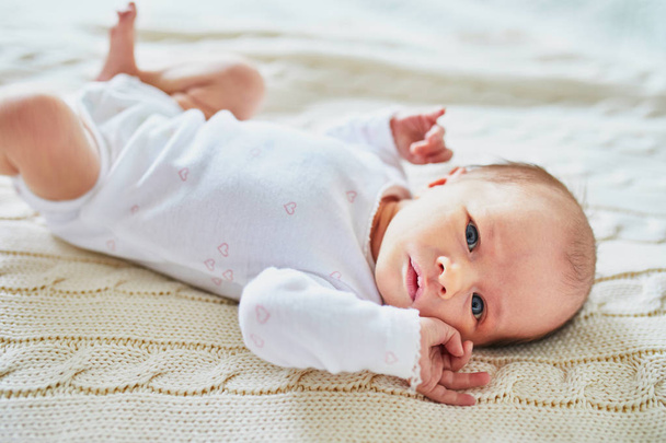 Adorable baby girl lying on bed in nursery - Photo, Image