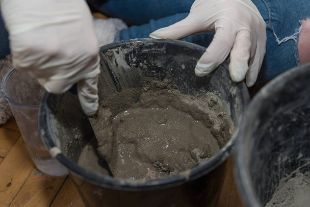 Persoon mengt water, zand en cement op een beton - close-up - Foto, afbeelding