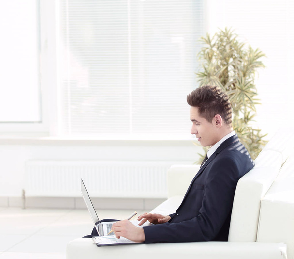 confident businessman working on laptop sitting in the spacious  - Photo, Image