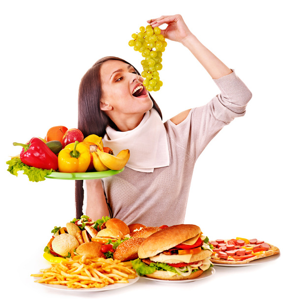 Femme au choix entre fruits et hamburger
. - Photo, image