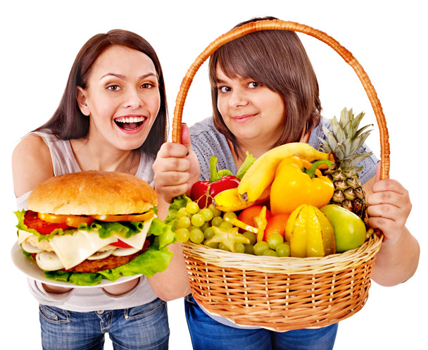 kobiety decydują między owoców i hamburger. - Zdjęcie, obraz