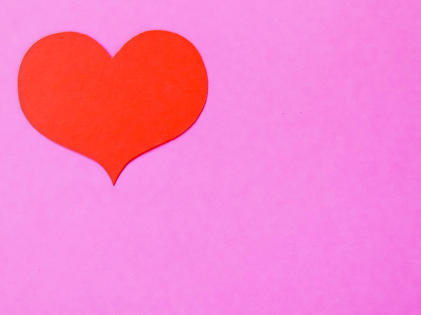 Red paper hearts on a pink paper background - Foto, Imagem