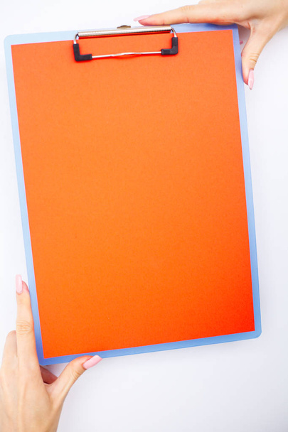 Blank Folder with ?range Paper. Hand that Holding Folder and Handle on White Background. Copyspace. Place for Text. - Photo, Image