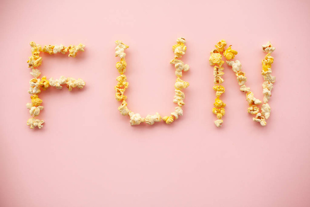 Food. Word of Fun. Popcorn bucket. Delicious Popcorn on Pink Background. Cinema. - Foto, afbeelding