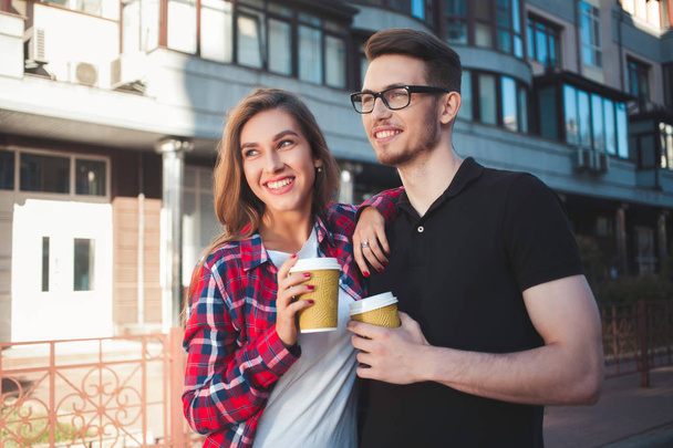 通りで飲むコーヒー歩く素晴らしいカップル - 写真・画像