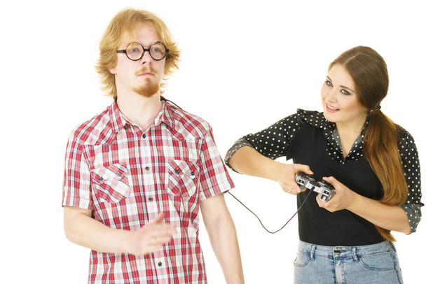 Woman being bossy having fun while steering man using gaming pad. Female controling her boyfriend. - Zdjęcie, obraz
