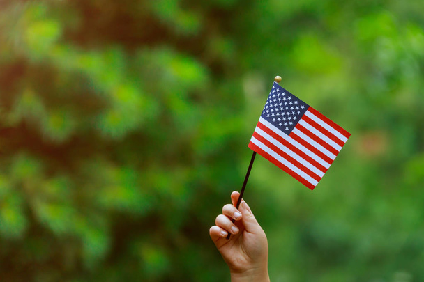 schöne amerikanische Flagge in der Hand lachend am sonnigen Unabhängigkeitstag, Flaggentag Konzept - Foto, Bild