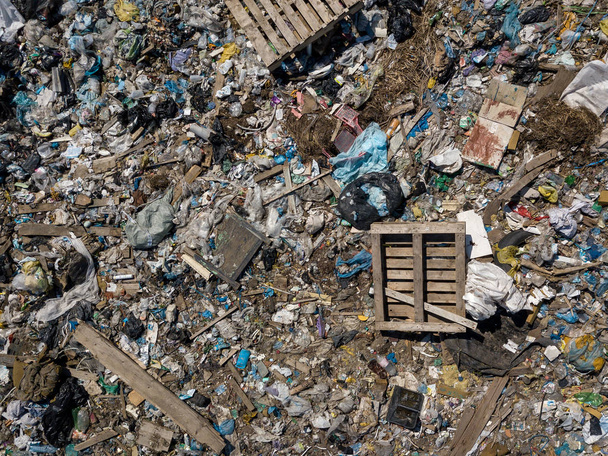 Загрязнение окружающей среды Снимок сверху с летающего беспилотника из большой кучи мусора. Свалка мусора на свалке или свалке возле зеленого леса
. - Фото, изображение