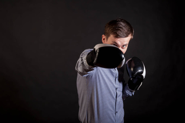 Dark-haired man in a plaid shirt with boxing gloves on his hands - Photo, Image