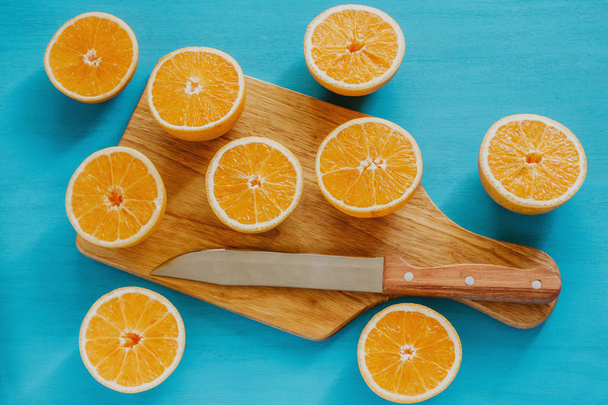 laranjas, suco de laranja e fatias de frutas em fundo azul
 - Foto, Imagem