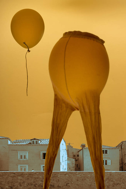 surrealistische Komposition "Abschied", eine Collage aus Stadtlandschaft, Ballon und Damenstrumpfhosen - Foto, Bild
