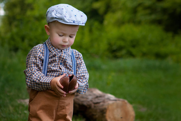Little boy with a large chocolate egg in the nature. - Photo, Image