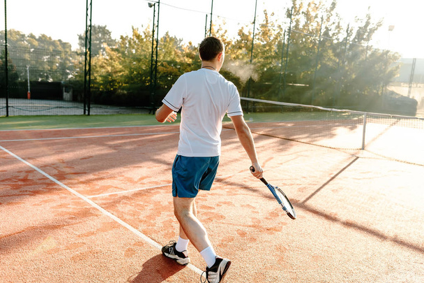  Man playing tennis in the morning in sunlight - Foto, imagen