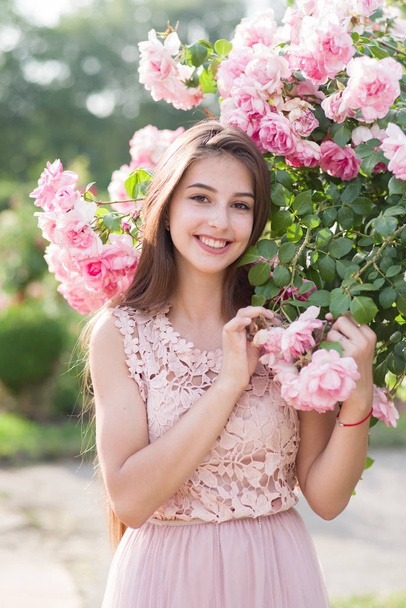 κορίτσι και τριαντάφυλλα, πορτρέτο ενός κοριτσιού σε ένα τριαντάφυλλο Κήπος, τριαντάφυλλα - Φωτογραφία, εικόνα