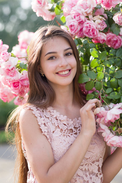 meisje en rozen, portret van een meisje in een roze tuin, rozen - Foto, afbeelding