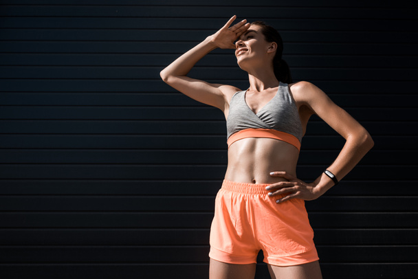 young sportswoman with fitness tracker looking away - Photo, Image