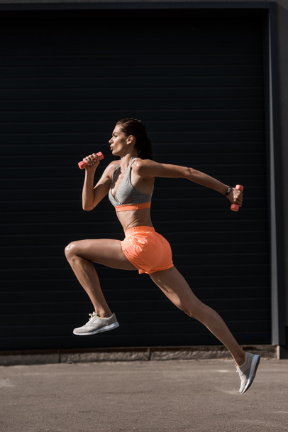 young attractive sportswoman running with little dumbbells  - Photo, Image