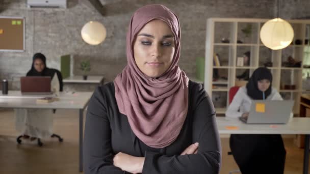 Young muslim women in hijab with crossed hands, shaking head in disagreement, three womens working on laptop in modern office - Filmagem, Vídeo
