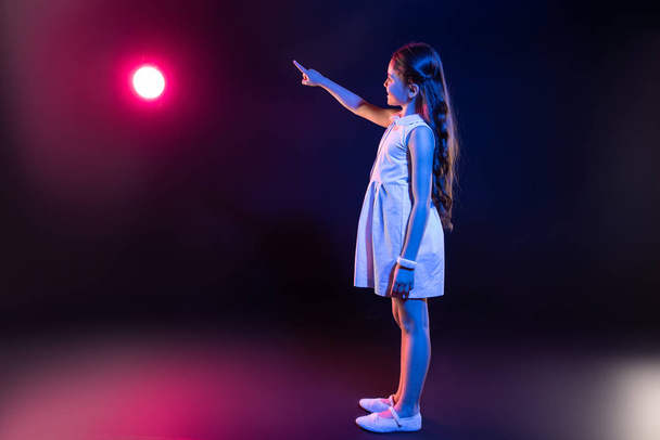 Content little girl pressing imaginary buttons - 写真・画像