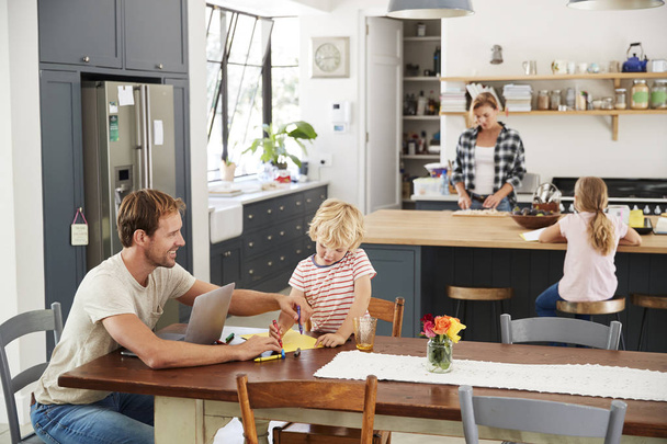 Young white family busy in their kitchen, elevated view - Foto, Bild
