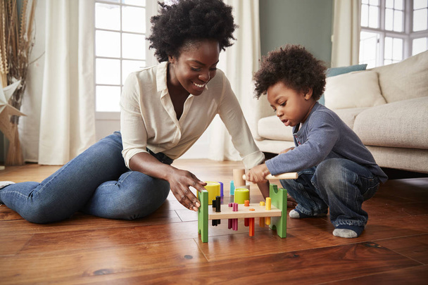 Mother And Young Son Playing With Wooden Toy At Home - Photo, image