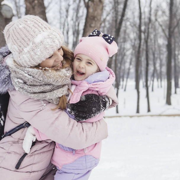 Happy loving caucasian family of mother father and daughter play, having fun in winter snowy park. Cute little girl playing - 写真・画像