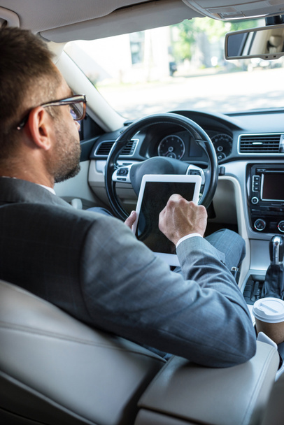 partial view of businessman in eyeglasses using tablet in car - Foto, Imagen