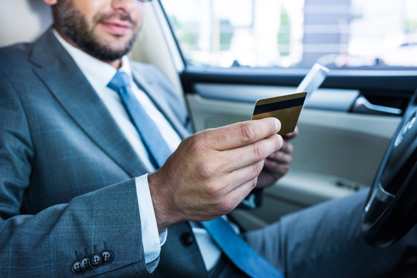 partial view of businessman with tablet and credit card sitting in car - 写真・画像
