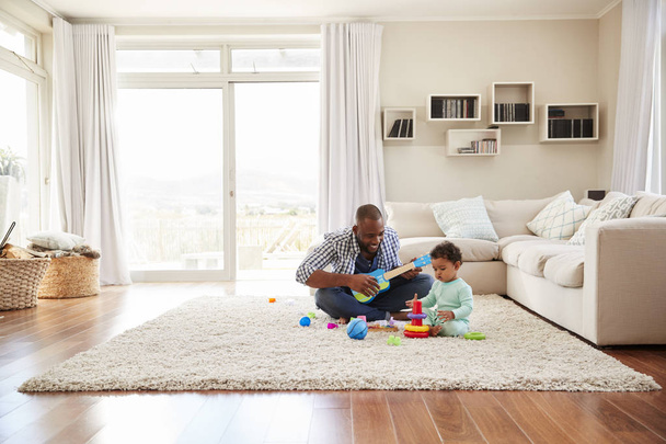 Black father and toddler son playing in sitting room - Photo, Image