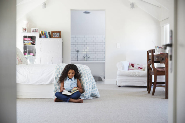 girl reading book alone in bedroom - Zdjęcie, obraz