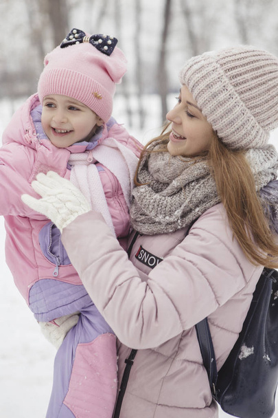 Happy loving caucasian family of mother father and daughter play, having fun in winter snowy park - Foto, Imagem
