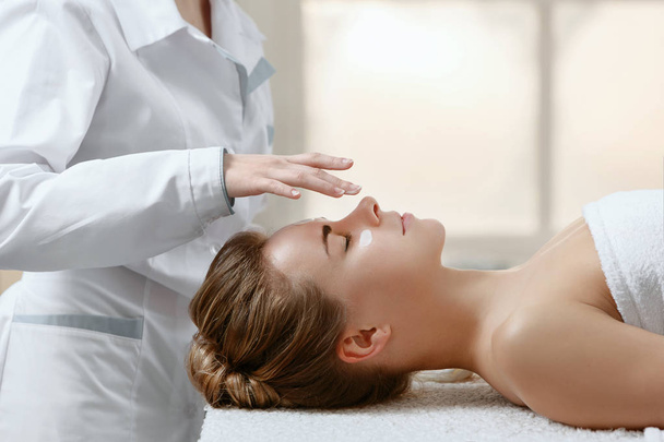 Dokter masseur terapist maakt medische en ontspannende massage voor meisje in de patiënt in lichte massage salon - Foto, afbeelding