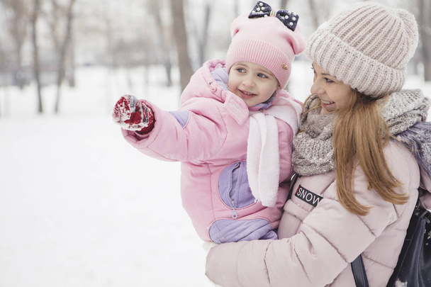 glücklich liebende kaukasische Familie von Mutter, Vater und Tochter spielen, Spaß haben im schneebedeckten Winterpark - Foto, Bild