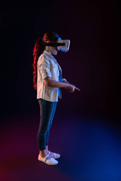 Content schoolgirl wearing a VR headset - Valokuva, kuva