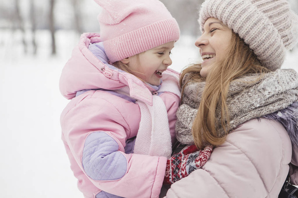 Happy loving caucasian family of mother father and daughter play, having fun in winter snowy park - 写真・画像