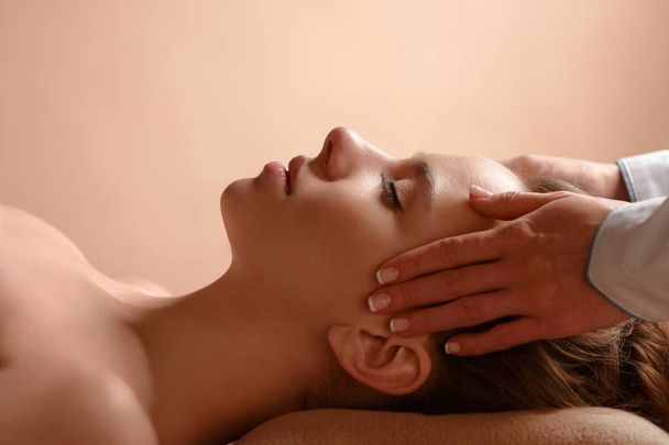 The masseuse makes relaxing head massage and spa client to young girl. - 写真・画像