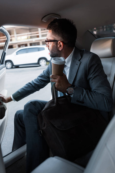 homme d'affaires avec café pour aller assis dans la voiture avec porte ouverte
 - Photo, image