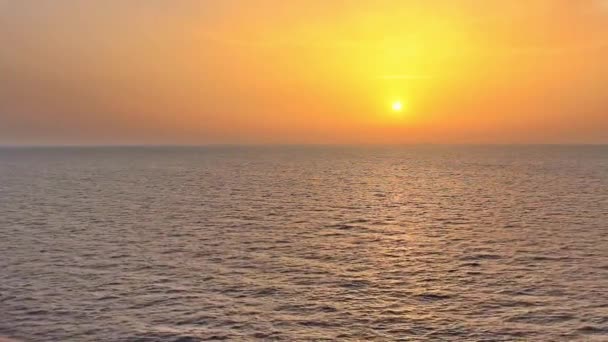 um pôr do sol espetacular no mar visto de um barco em navegação / o pôr do sol pinta o céu laranja e amarelo e reflete as cores no mar
 - Filmagem, Vídeo