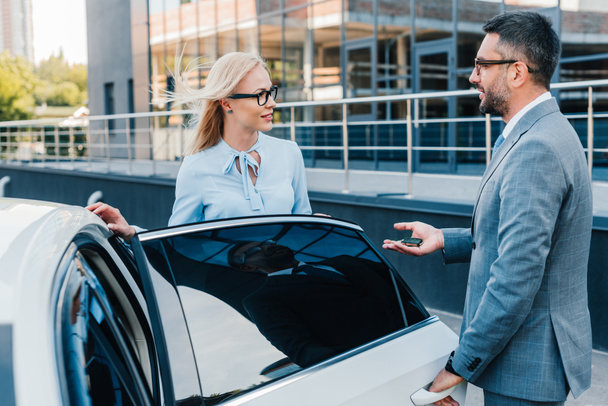 side view of business colleagues having conversation near car on street - Photo, Image