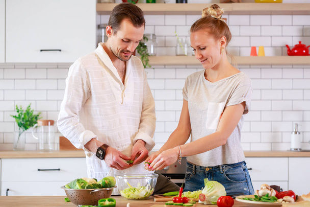 Imagen de pareja amorosa cocinando verduras en la cocina
 - Foto, imagen
