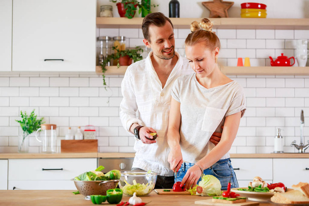 Picture of beautiful couple in love preparing breakfast in kitchen - Fotó, kép