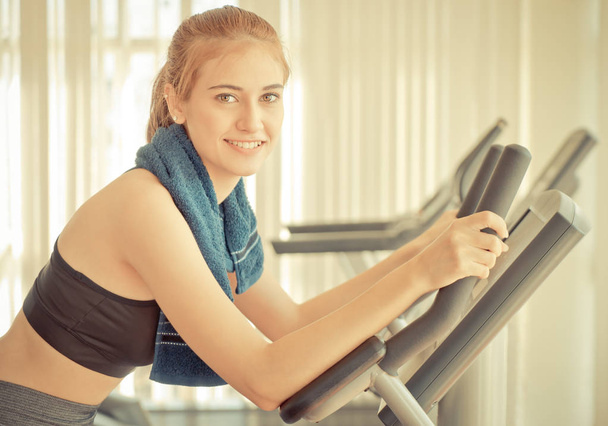 Happy Woman is training on fitness machine - Photo, Image