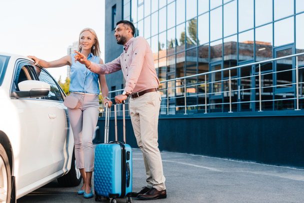 husband and wife with baggage standing at car on parking - Foto, Imagem